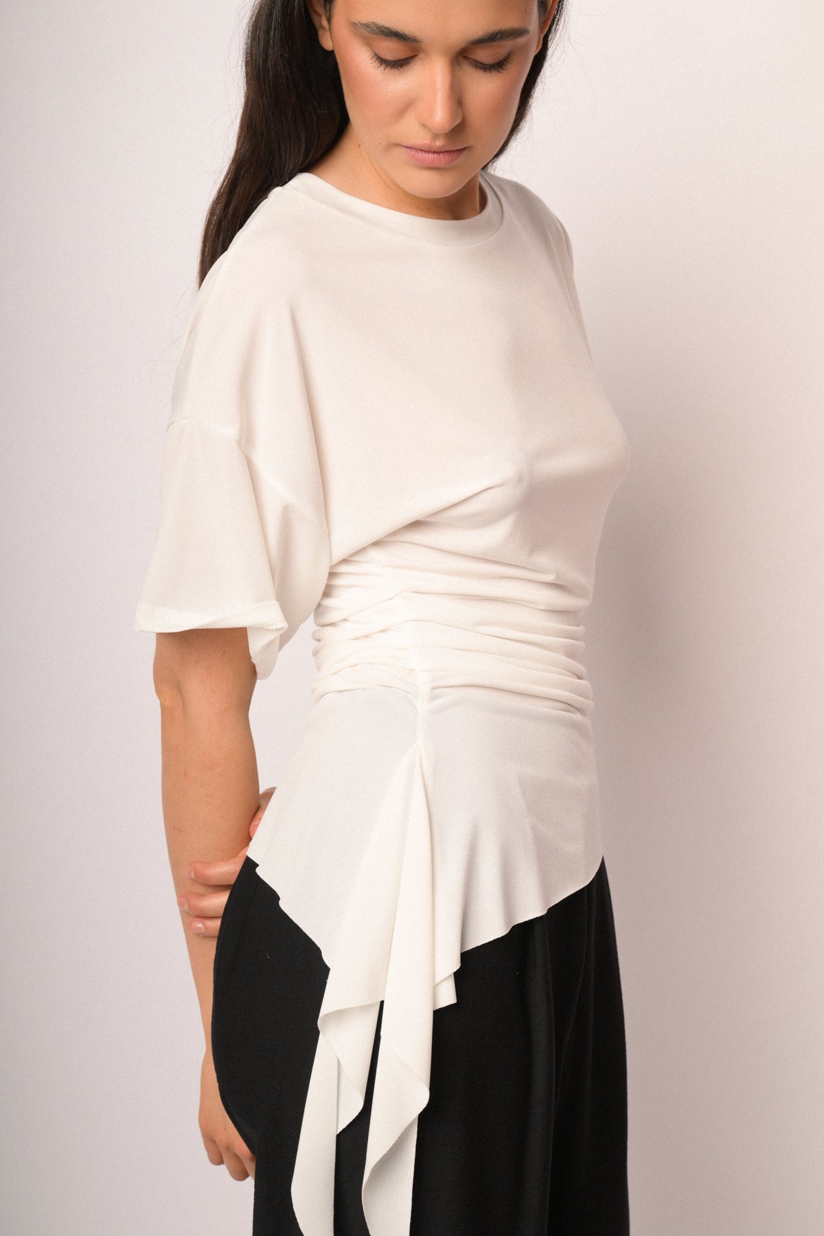 Maglia color panna drappeggiata con fondo asimmetrico