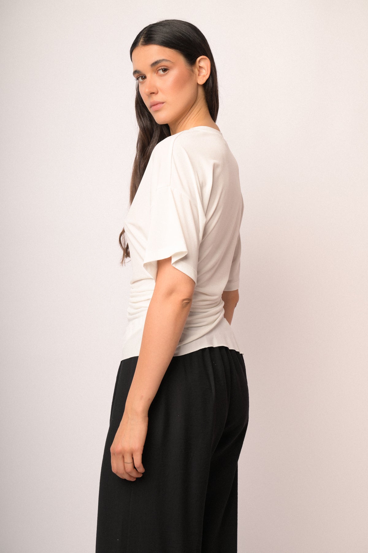 Maglia color panna drappeggiata con fondo asimmetrico