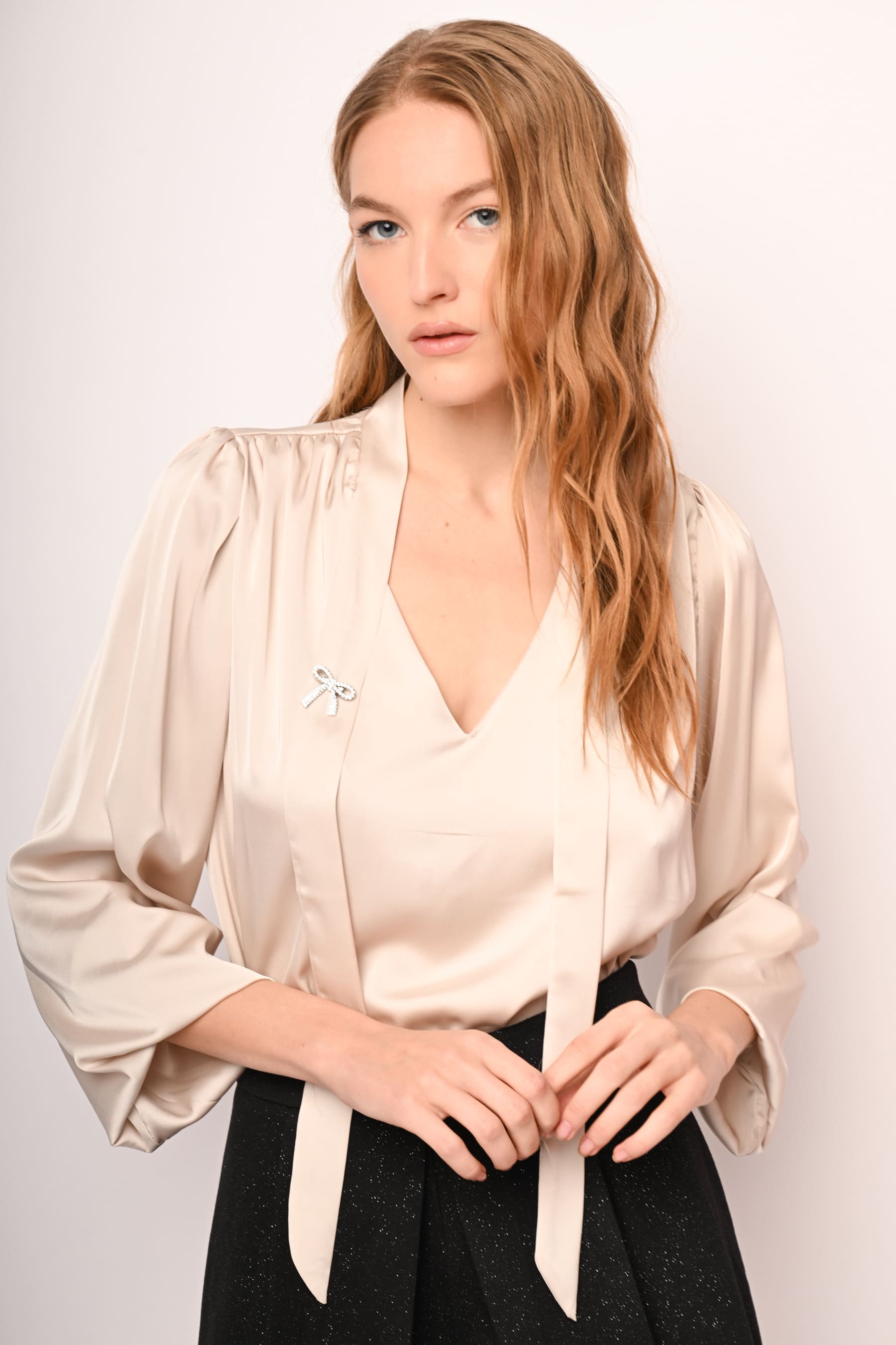 Blusa in raso con laccio e spilla