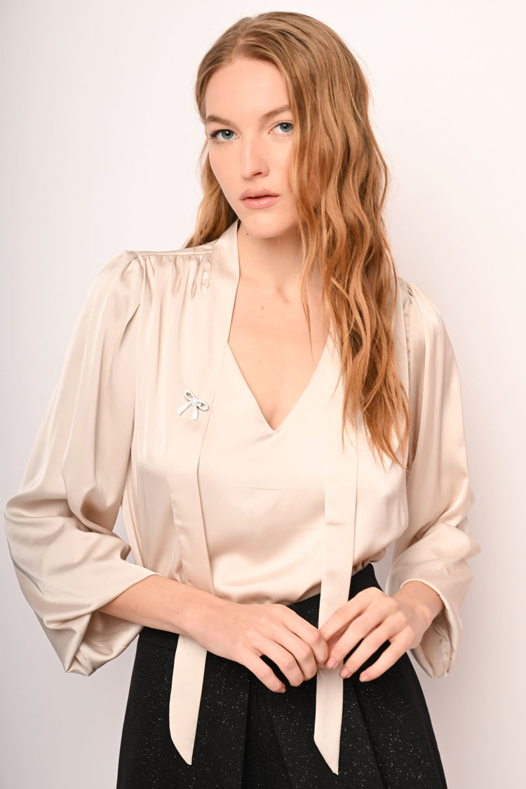 Blusa in raso con laccio e spilla