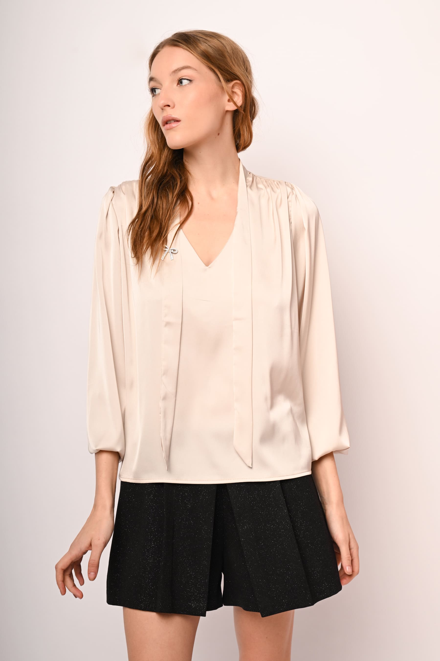 Blusa in raso con laccio e spilla