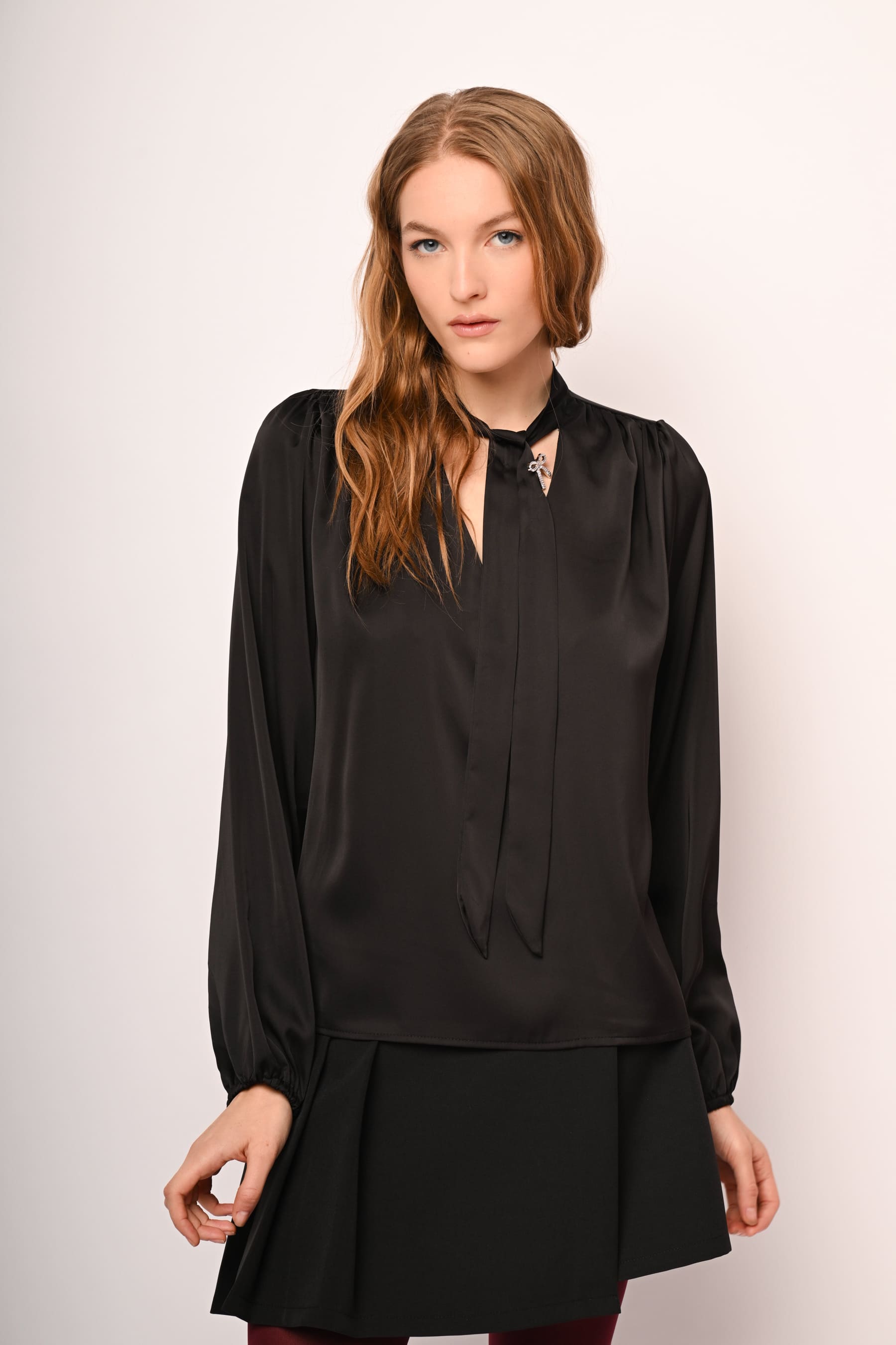 Blusa in raso con laccio e spilla