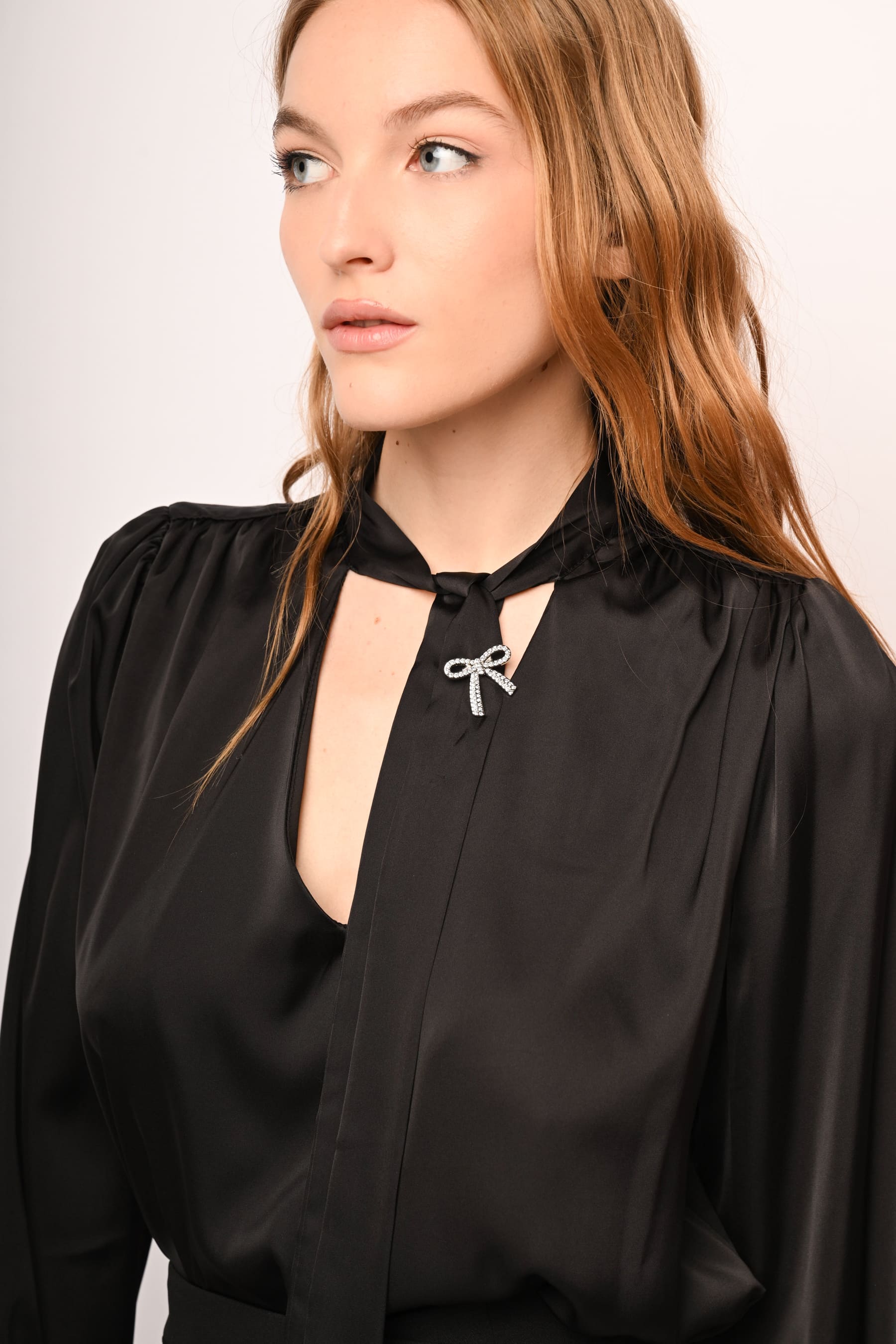 Blusa in raso con laccio e spilla