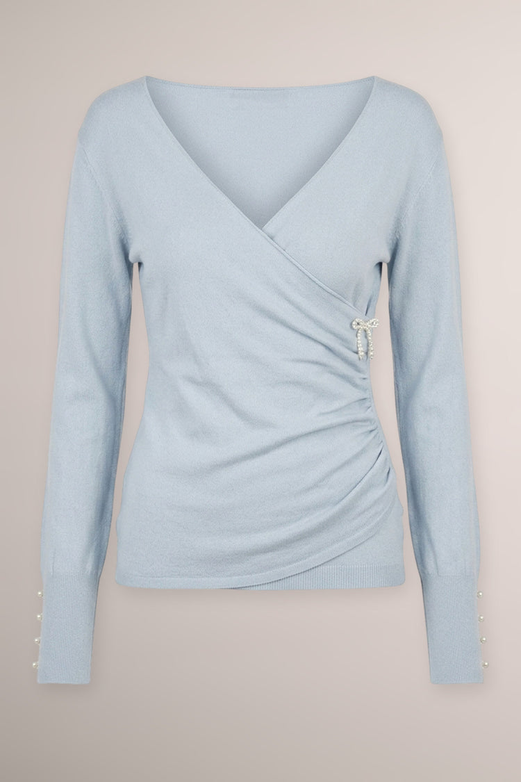 Pull incrociato celeste con fiocchetto in perline