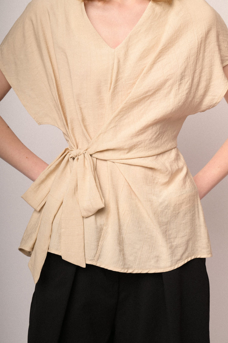 Top beige con scollo a V e fiocco da annodare