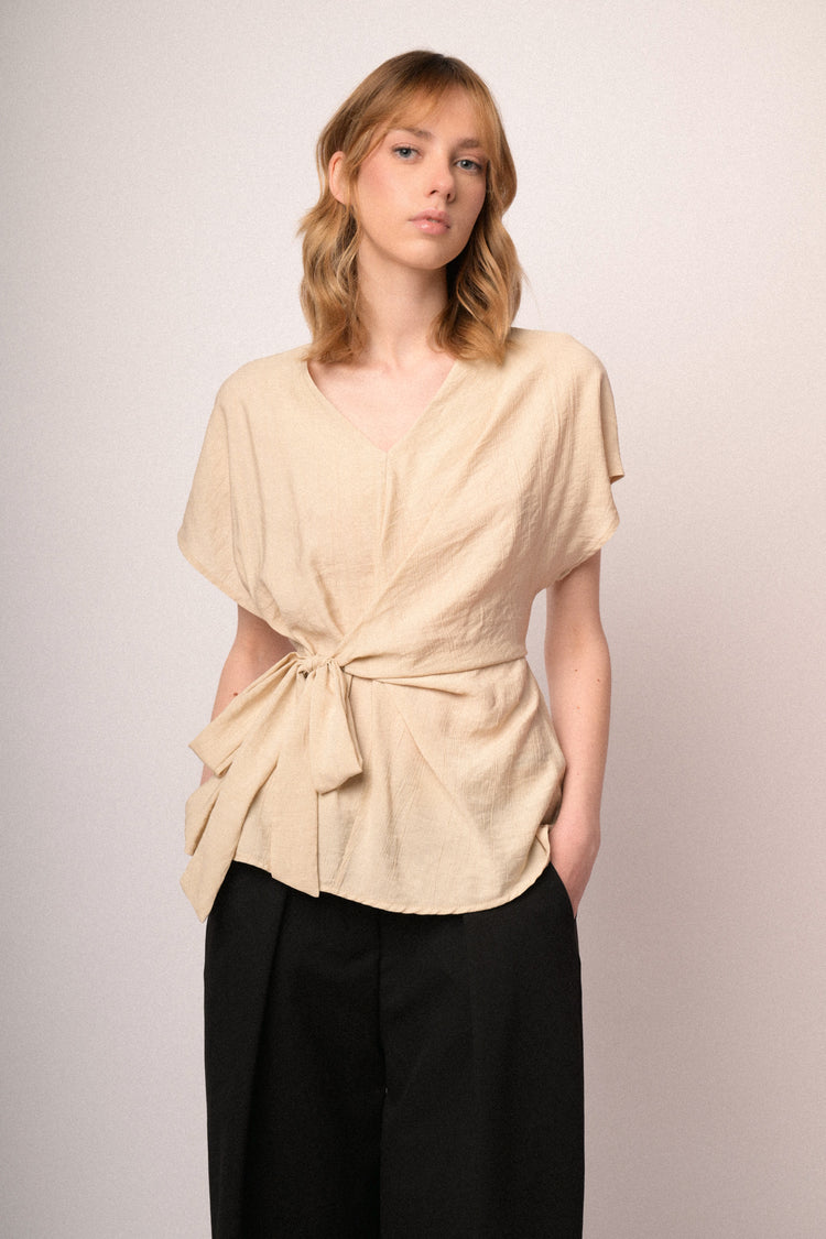 Top beige con scollo a V e fiocco da annodare